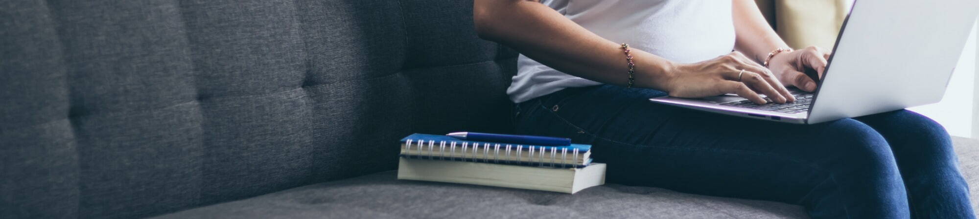 Woman working on her laptop on the couch cropped